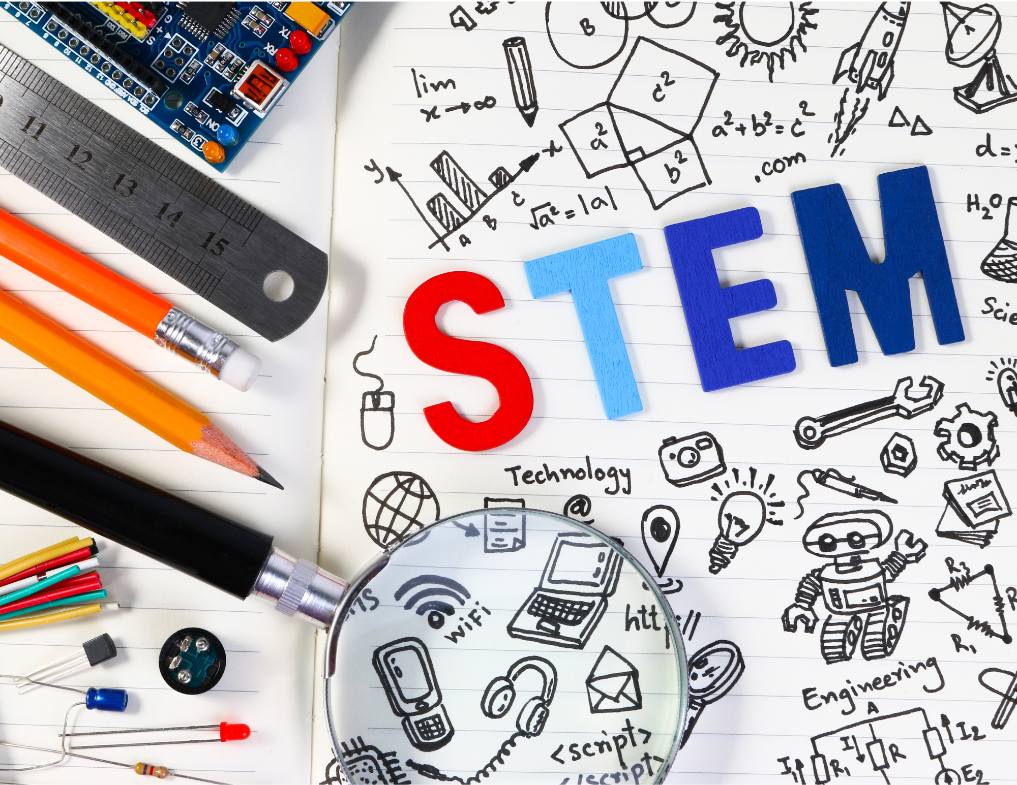 Pencils, ruler, pens lay beside a doodle reading "STEM"