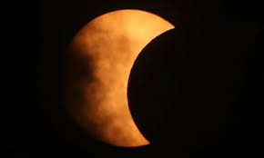 A Partial Eclipse, showing the shadow of the moon partially covering the sun.