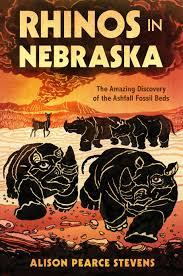 The cover of the book, "Rhinos in Nebraska" depicts two prehistoric rhinos, illustrated in black, running in the foreground. In the back, more prehistoric animals, illustrated in black, roam an orange plain, with a volcano looming over the distance.