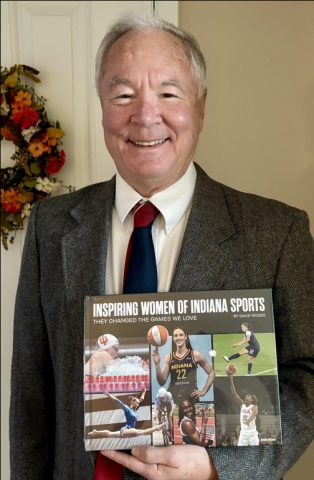 Author David Woods holding a copy of his new book Inspiring Women of Indiana Sports