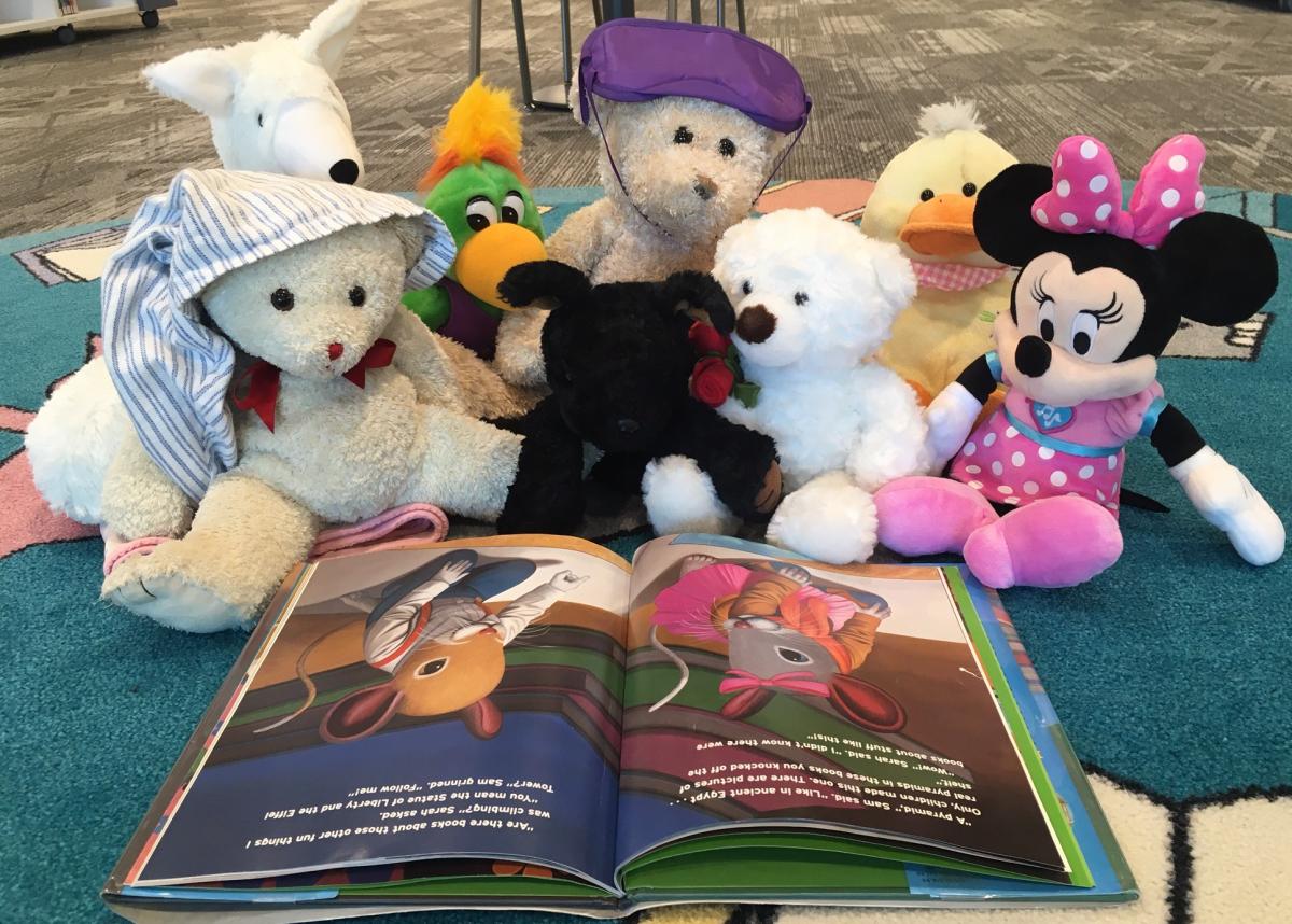 stuffed animals reading a book