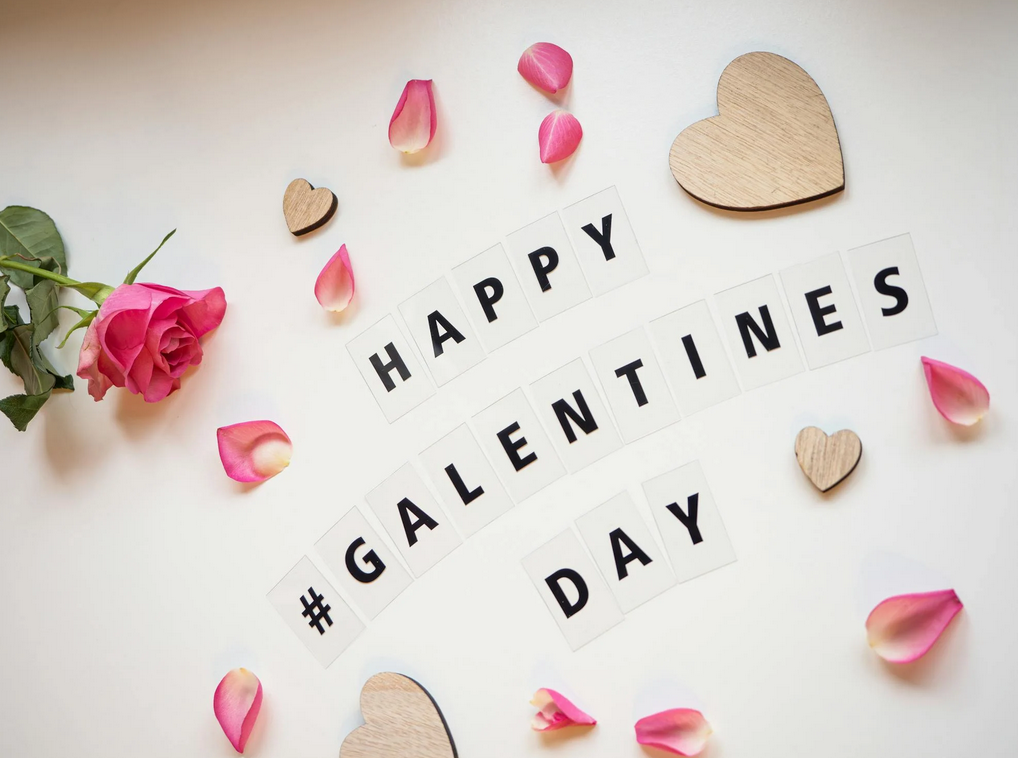 Happy #Galentines Day in black letters surrounded by flower petals 